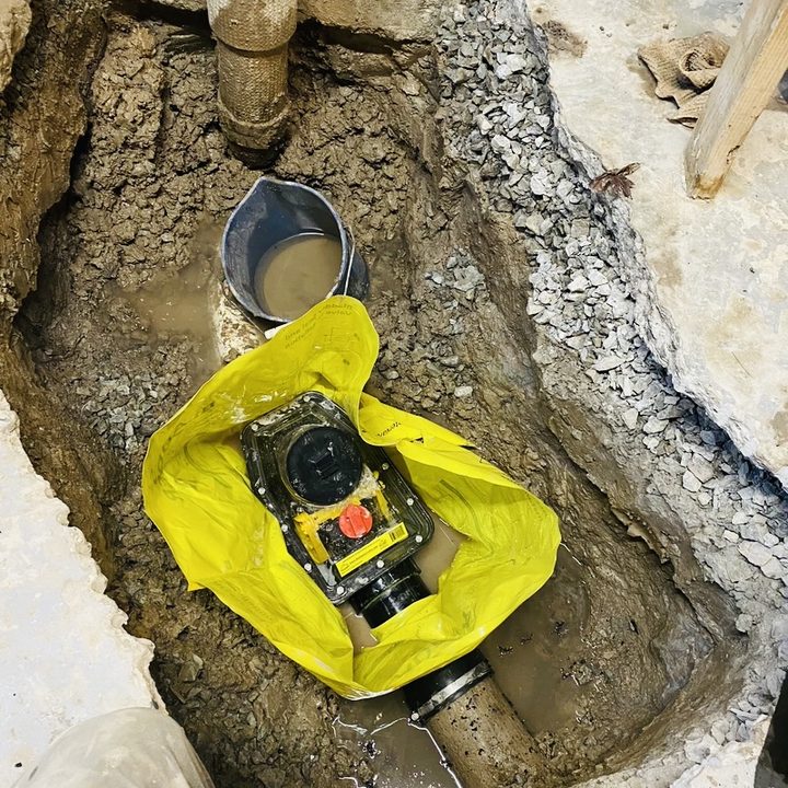 A new backwater valve set into an open trench in a basement floor.