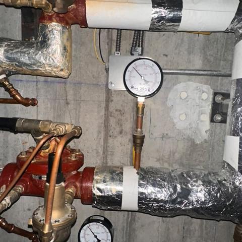 Pressure gauges and valves on insulated piping.